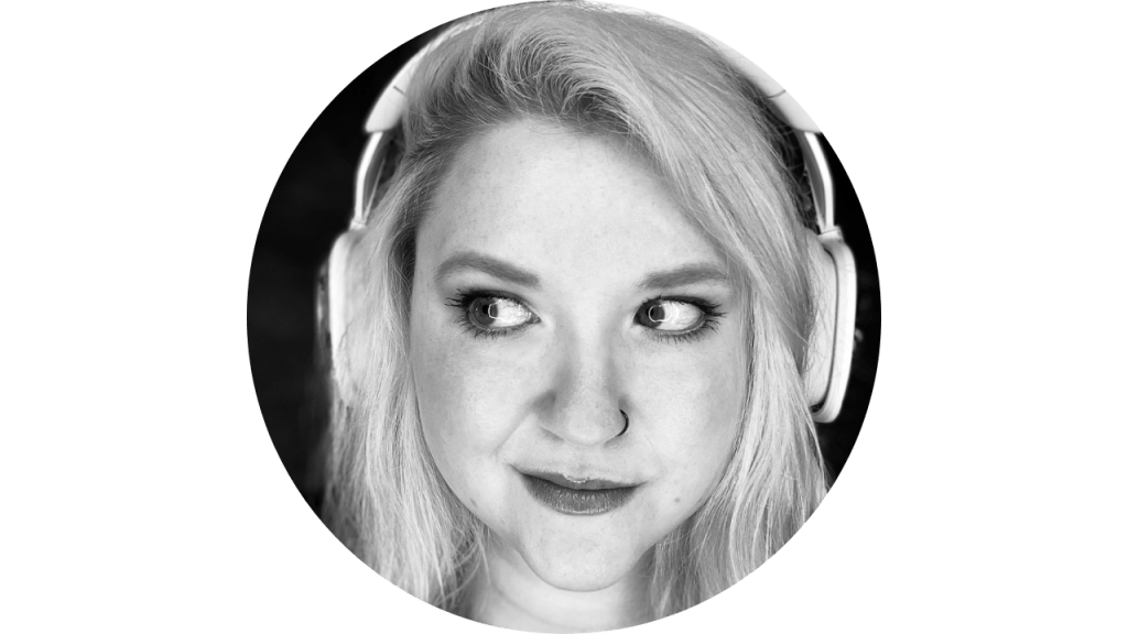 Black and white headshot photo of a white woman in her thirties, wearing headphones